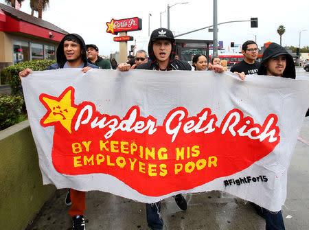 Local fast food workers take part in nationwide protests to denounce President-elect Donald Trump's nomination of Andy Puzder, a restaurant mogul who owns Carl's Jr. and other chains, as U.S. Secretary of Labor outside a Carl's Jr. restaurant in Los Angeles, California, U.S., January 12, 2017. REUTERS/Mike Blake