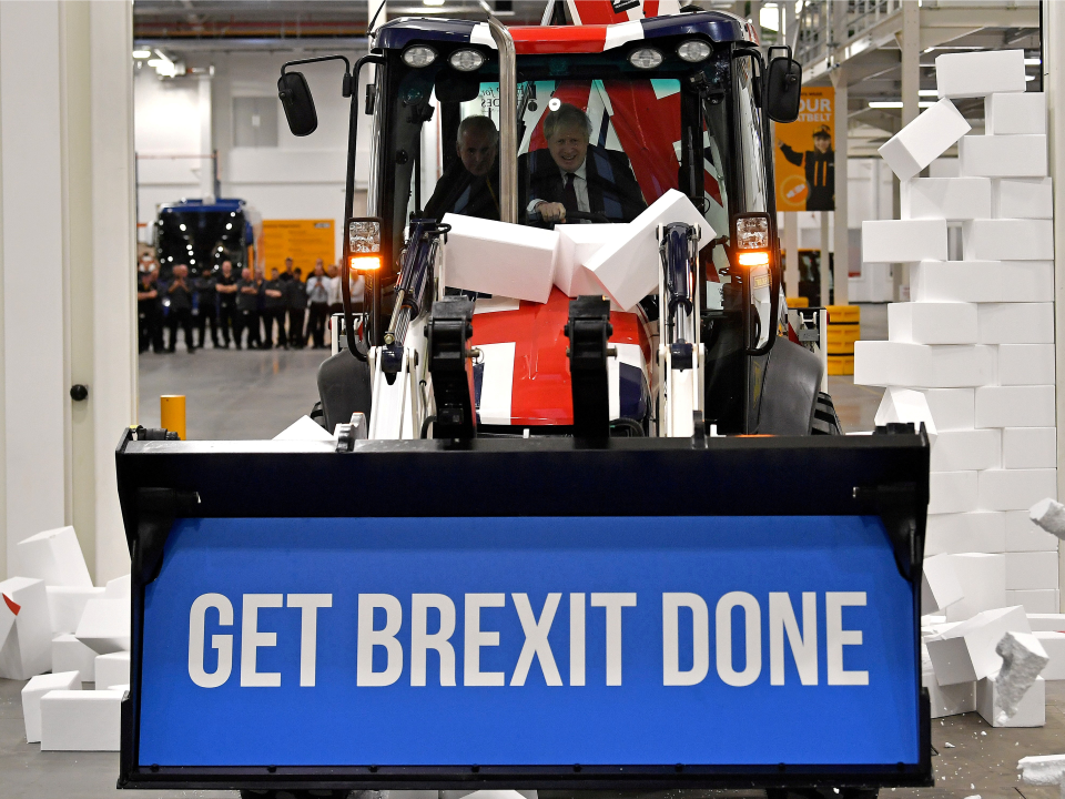 FILE PHOTO: Britain's Prime Minister and Conservative leader Boris Johnson drives a Union flag-themed JCB, with the words 
