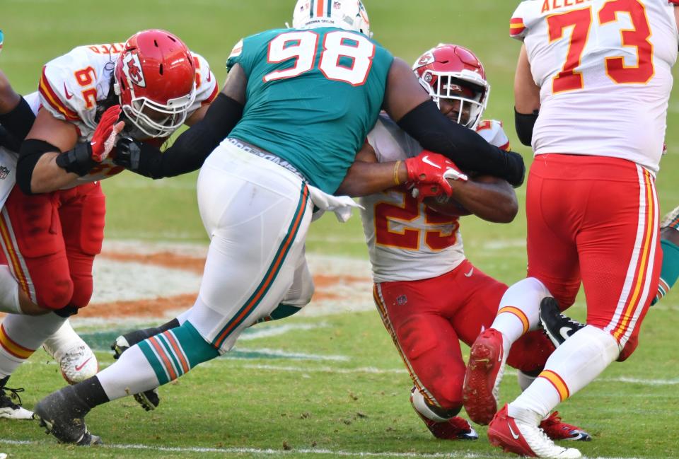 Miami Dolphins nose tackle Raekwon Davis (98) brings down Kansas City Chiefs running back Clyde Edwards-Helaire (25) in the fourth quarter at Hard Rock Stadium in Miami Gardens, December 13, 2020. 