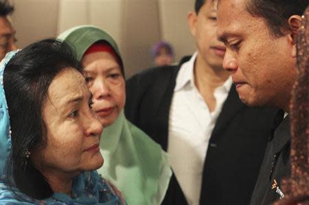 Rosmah Mansor (L), wife of Malaysian Prime Minister Najib Razak, cries with family members of passengers on the missing Malaysia Airlines flight MH370, at a hotel in Putrajaya March 9, 2014. REUTERS/Zulfadli Zaki