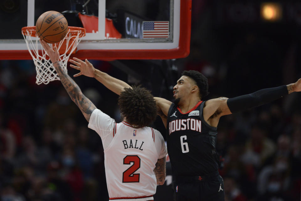 Chicago Bulls guard Lonzo Ball (2) makes a basket against Houston Rockets forward Kenyon Martin Jr. (6) during the first half of an NBA basketball game Monday, Dec. 20, 2021, in Chicago. (AP Photo/Paul Beaty)
