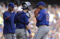 New York Mets' Carlos Carrasco (59) talks with Tomas Nido and pitching coach Jeremy Hefner, left, during the second inning of a baseball game against the Milwaukee Brewers, Sunday, Sept. 26, 2021, in Milwaukee. (AP Photo/Aaron Gash)