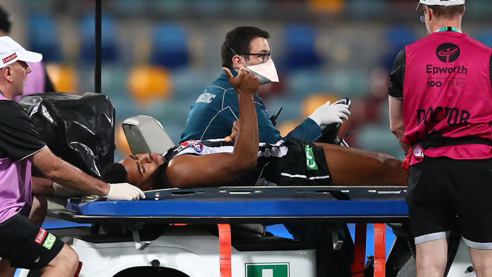 Pictured here, Isaac Quaynor gives the thumbs up as he is stretchered off the field.