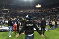 Police stand on the pitch after Besiktas' and Lyon's supporters fought before the UEFA Europa League first leg quarter final football match April 13, 2017, at the Parc Olympique Lyonnais stadium in Decines-Charpieu