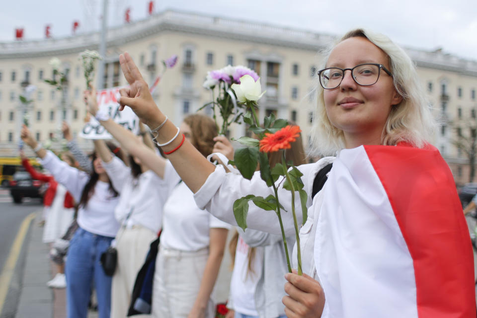 Mujeres con flores en la mano protestan contra el gobierno en la Plaza de la Victoria, en Minsk, Bielorrusia, el jueves 20 de agosto de 2020. (AP Foto/Sergei Grits)