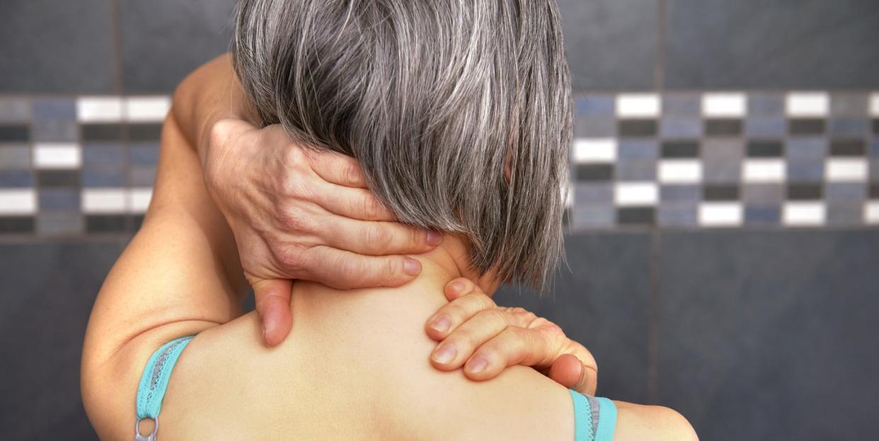 woman rubbing back of neck