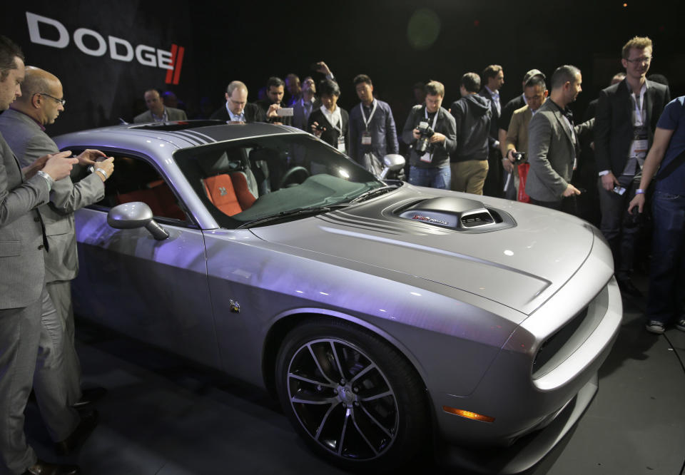 Poeple gather around the 2015 Dodge Challenger after it is introduced at the New York International Auto Show in New York, Thursday, April 17, 2014. (AP Photo/Seth Wenig)