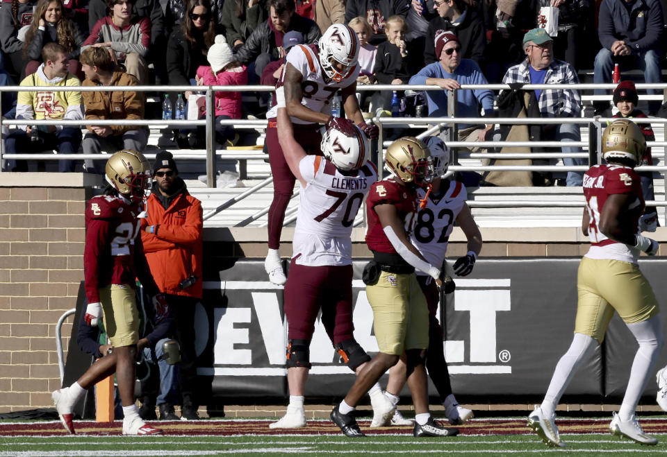 Virginia Tech offensive lineman Parker Clements (70) lifts tight end Harrison Saint Germain (87) after Saint Germain scored during the first half of an NCAA college football game against Boston College, Saturday, Nov. 11, 2023 in Boston. (AP Photo/Mark Stockwell)