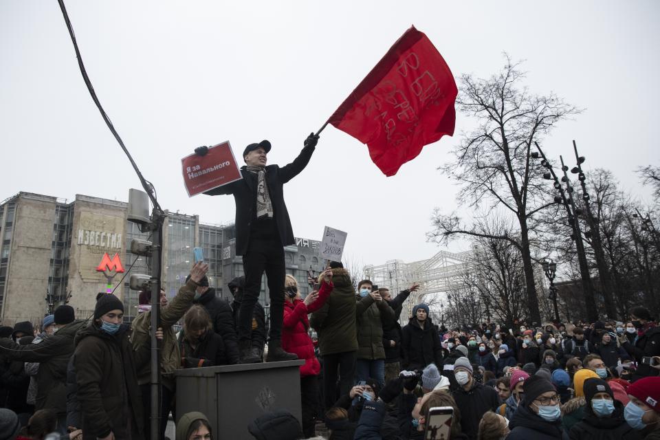 FILE - In this Jan. 23, 2021, file photo, a demonstrator waves a red flag and holds a banner that reads: "I'm for Navalny," at a protest supporting jailed opposition leader Alexei Navalny in Moscow, Russia. Rattled by the nationwide demonstrations supporting him, Russian authorities are moving rapidly to block any new ones – from piling legal pressure on his allies to launching a campaign to discredit the rallies. (AP Photo/Pavel Golovkin, File)