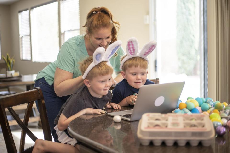 a family celebrating easter while social distancing using a laptop to talk to friends and family