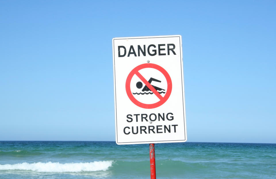 A "Danger Strong Current" sign at a beach