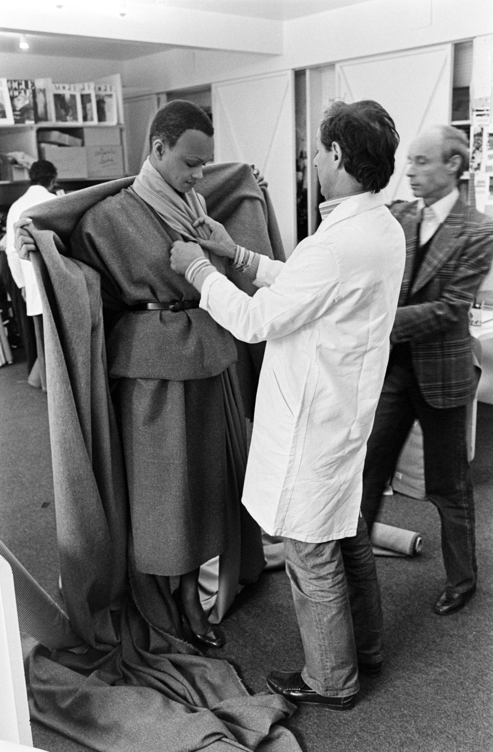 Marc Bohan adjusts a look on a model during a fit session for the Christian Dior fall 1978 Haute Couture collection at the Dior design studios in Paris on July 7, 1978.