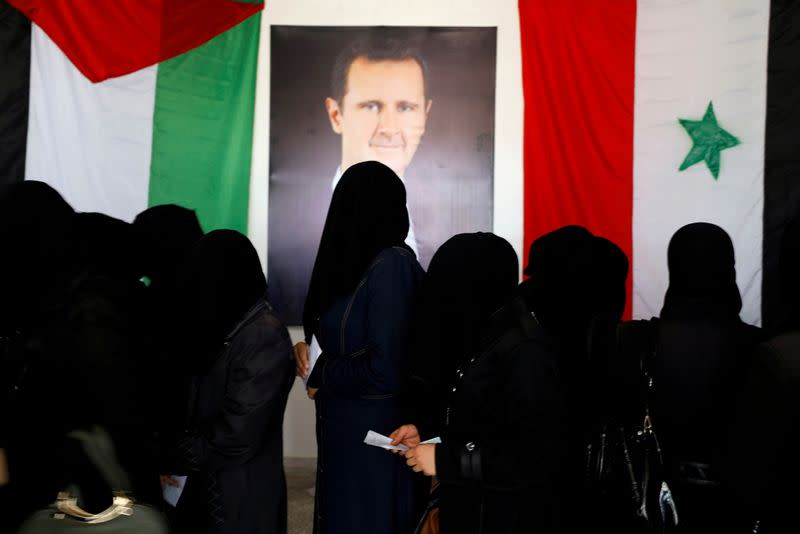 FILE PHOTO: Women stand as they wait their turn to cast the votes inside a polling station during the parliamentary elections in Douma