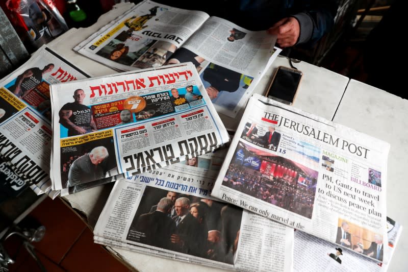 A man sits in a coffee shop next to the main Israeli Newspapers in Jerusalem