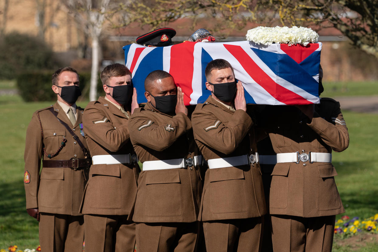 BEDFORD, ENGLAND - FEBRUARY 27: (No reuse after 11.59pm on March 6th 2021 without written consent from gemma@captaintom.org.) The coffin of Captain Sir Tom Moore is carried by members of the Armed Forces during his funeral at Bedford Crematorium on February 27, 2021 in Bedford, England. WWII veteran, Sir Tom raised nearly £33 million for NHS charities ahead of his 100th birthday last year by walking laps of his garden in Marston Moretaine, Bedfordshire. He died on the 2nd of February after testing positive for COVID-19. (Photo by Joe Giddens - Pool/Getty Images)