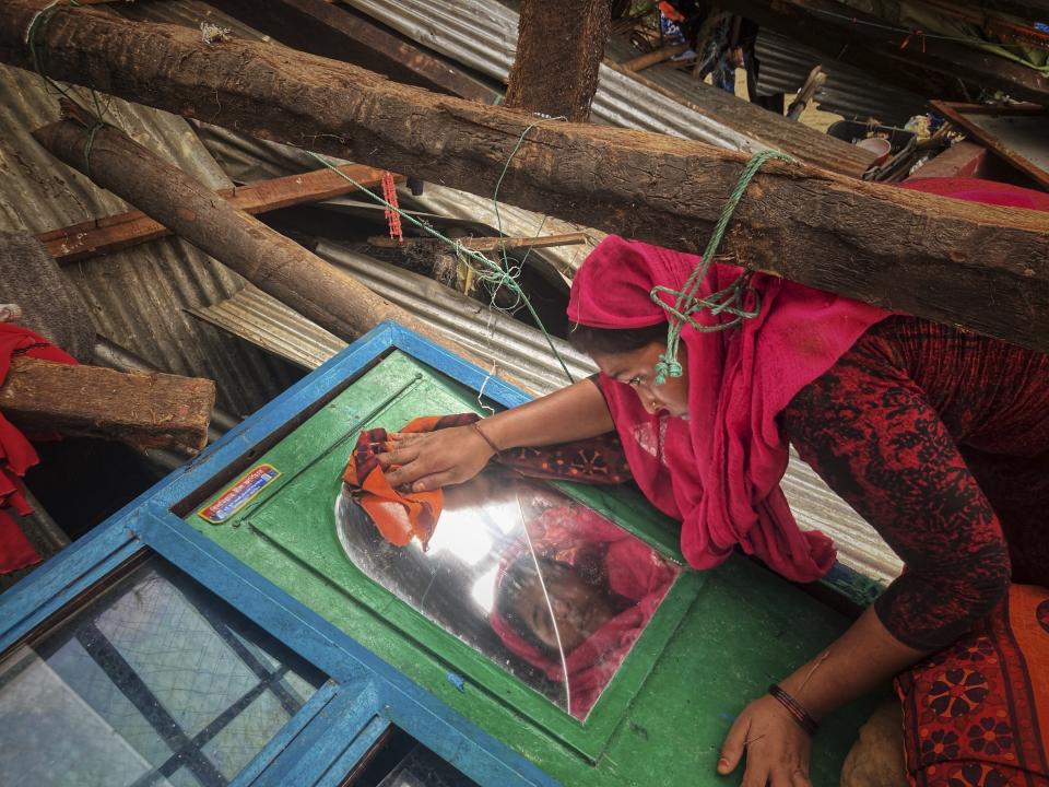 FILE - A woman salvages belongings from her home damaged by Cyclone Mocha at Saint Martin island in Cox's Bazar, Bangladesh, Monday, May 15, 2023. The U.N. weather agency reported Monday that nearly 12,000 extreme weather, climate and water-related events over much of the last half-century around the globe have killed more than 2 million people and caused economic damage of $4.3 trillion. (AP Photo/Al-emrun Garjon, File)