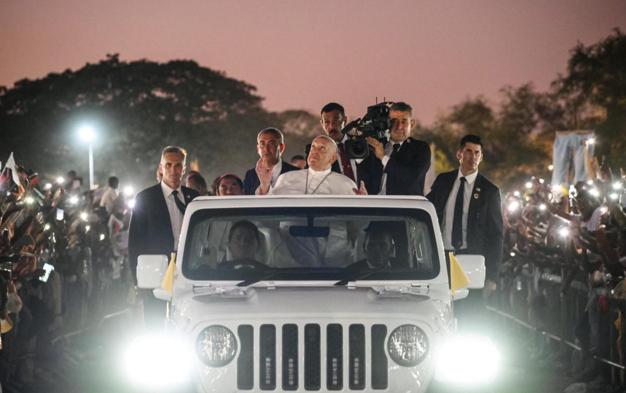 Pope Francis tours a field in East Timor in his open-topped popemobile