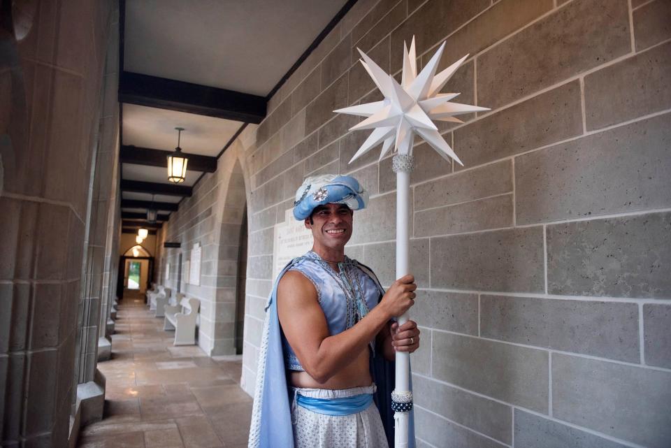 Dressed as the Star of the East, Carlos Gabino waits for his cue Saturday during the 2024 Boar's Head and Yule Log Festival.