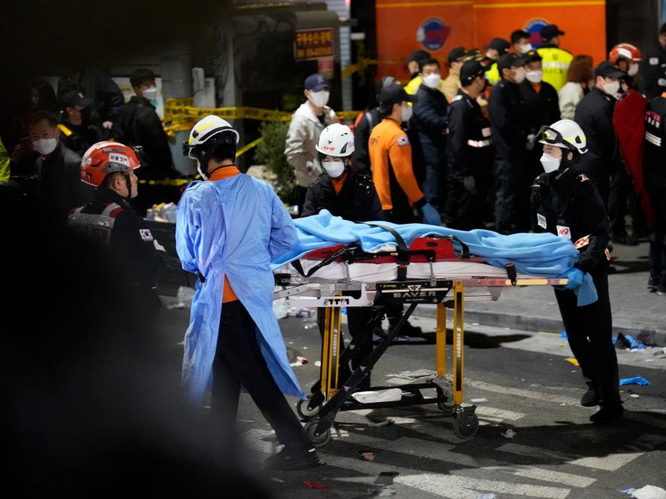 Rescue workers carry a victim on the street near the scene in Seoul, South Korea