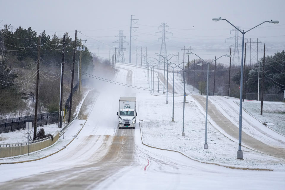 A truck rolls on a snow-covered road during a winter storm, Monday, Jan. 15, 2024, in Grand Prairie, Texas. (AP Photo/Julio Cortez)