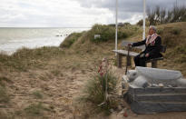 World War II D-Day veteran and Penobscot Elder from Maine, Charles Norman Shay sits on a bench next to his memorial stone at Omaha Beach prior to a ceremony in Saint-Laurent-sur-Mer, Normandy, France, Friday June 5, 2020. Saturday's anniversary of D-Day will be one of the loneliest remembrances ever, as the coronavirus pandemic is keeping almost everyone away, from government leaders to frail veterans who might not get another chance for a final farewell to their unlucky comrades. (AP Photo/Virginia Mayo)