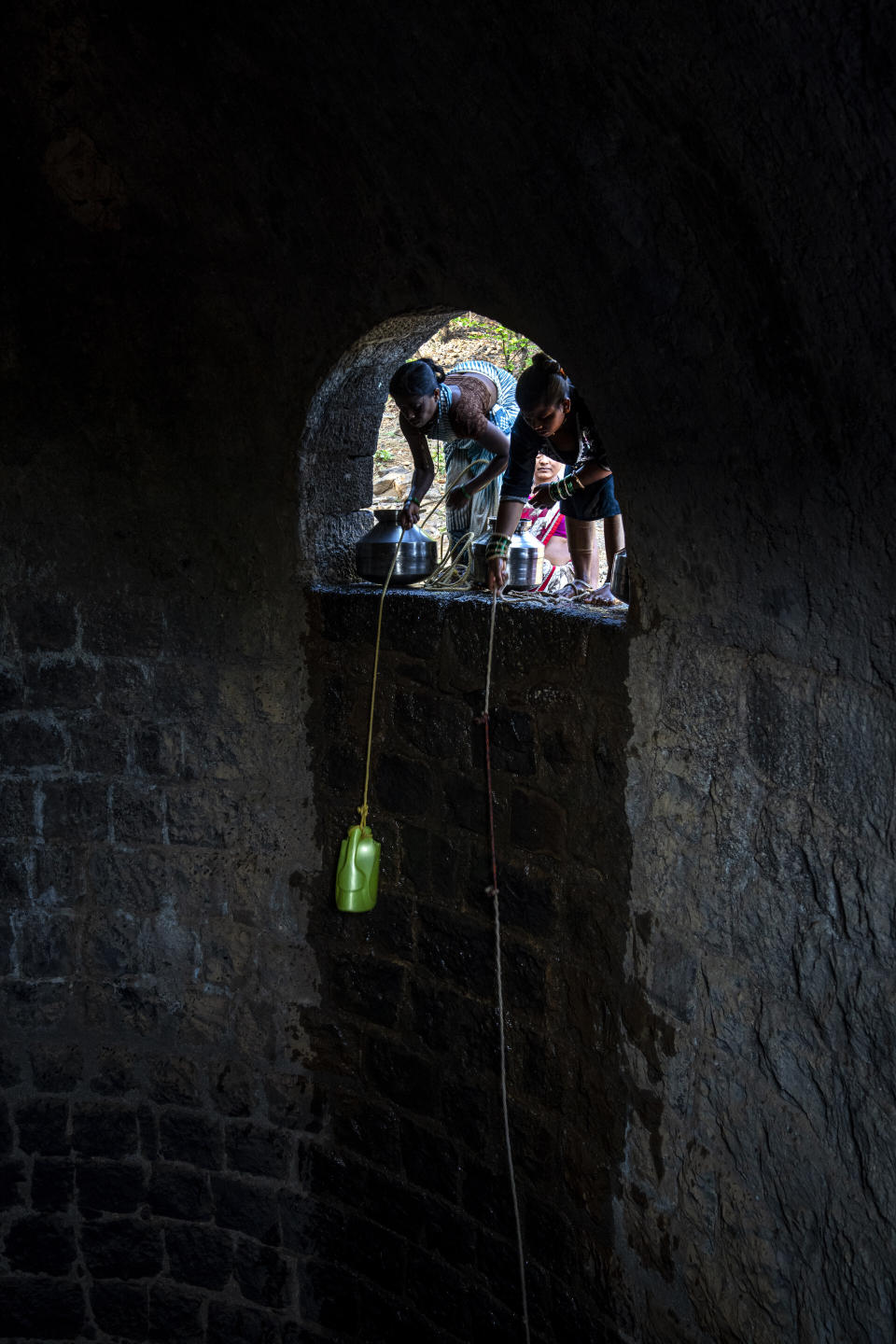 Women draw water from a well in the village of Bibalvadi, northeast of Mumbai, India, Saturday, May 6, 2023. The village is more than an hour's hike away for these women who walk as quickly and steadily as they can back to their homes, made of red brick, which offer a bit of respite from the extreme heat. (AP Photo/Dar Yasin)