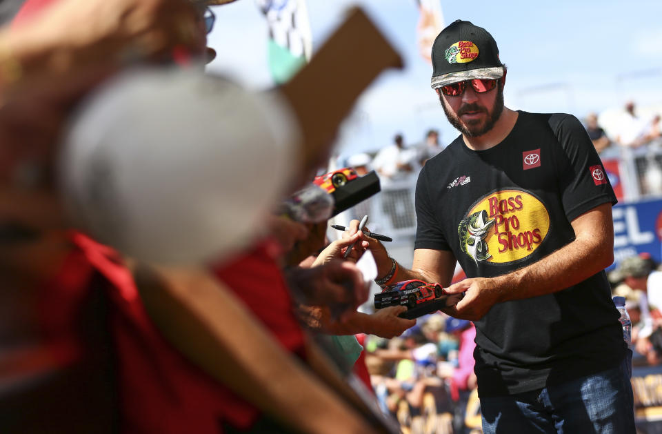 Martin Truex Jr. gives autographs to fans before a NASCAR Cup Series auto race at Las Vegas Motor Speedway, Sunday, Sept. 15, 2019. (AP Photo/Chase Stevens)