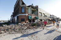 <p>A local resident runs past a tornado-damaged building on Main Street, Thursday, July 19, 2018, in Marshalltown, Iowa. Several buildings were damaged by a tornado in the main business district in town including the historic courthouse. (Photo: Charlie Neibergall/AP) </p>