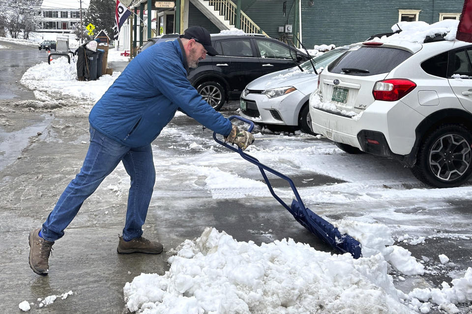 Bobby Searles shovels heavy, wet snow from a parking space outside the Cabot Village Store, Monday, Dec. 4, 2023, in Cabot, Vt. A storm dropped a mix of rain and snow on parts of New England, with some locations recording more than a half-foot of snow. (AP Photo/Lisa Rathke)