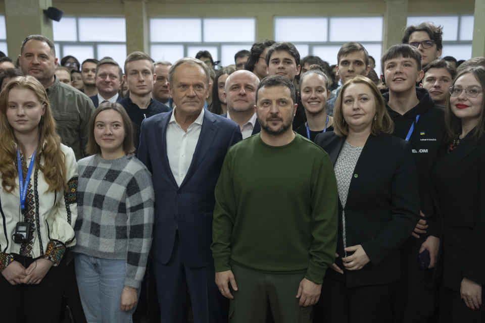 Ukrainian President Volodymyr Zelenskyy and Poland's Prime Minister Donald Tusk pose for photos with Ukrainian students after their meeting in Kyiv, Ukraine, Monday, Jan. 22, 2024. (AP Photo/Efrem Lukatsky)