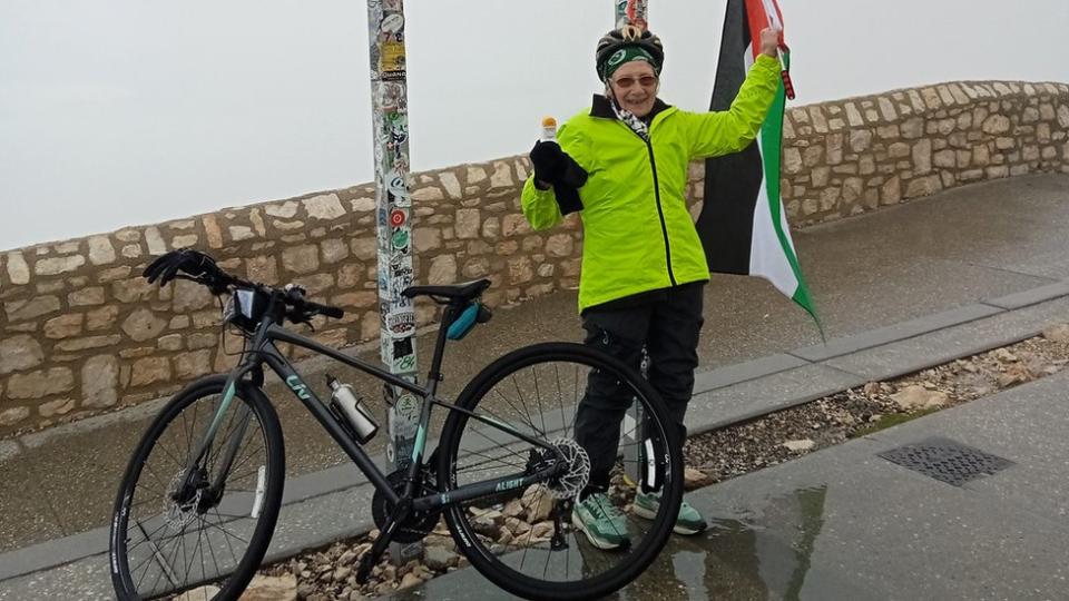 Anne Jones surrounded by fog with a Palestinian flag in her hand