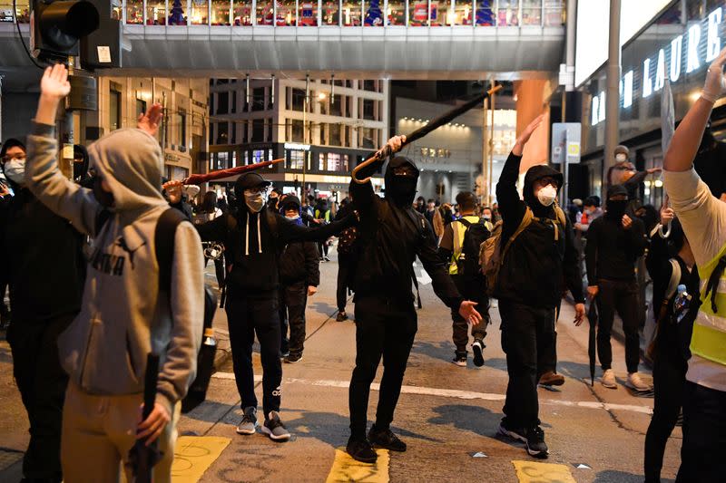 Protesters encourage others to leave at the end of a Human Rights Day march in the district of Central in Hong Kong