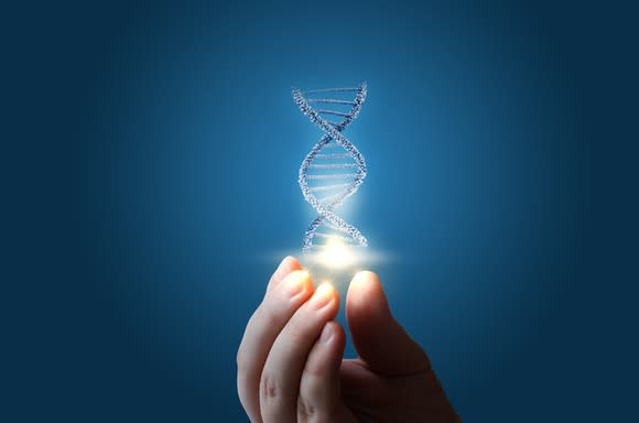 A hand holding up a piece of DNA.