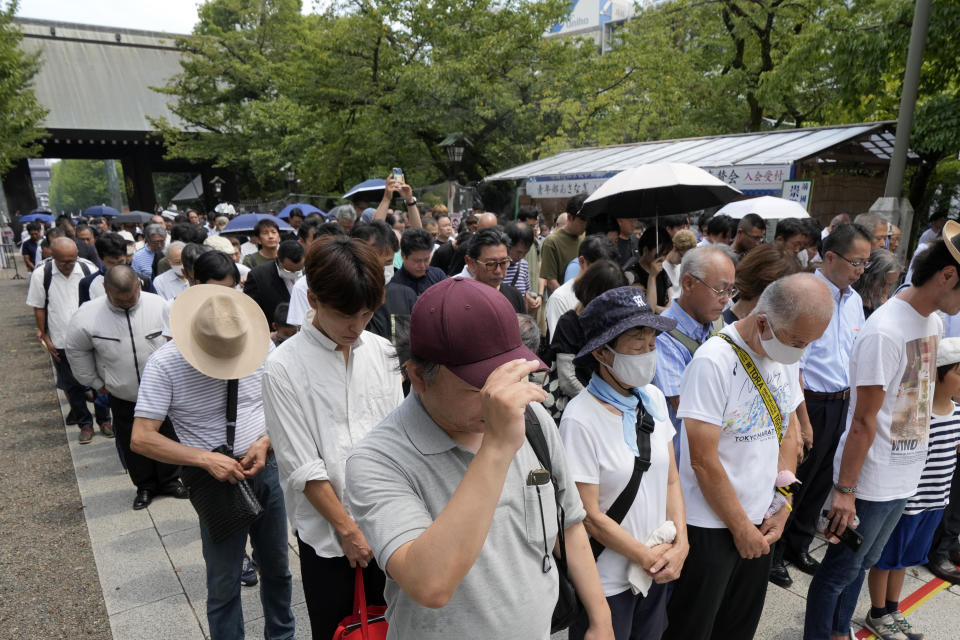 Visitors observe a minute of silence at noon at the Yasukuni Shrine, which honors Japan's war dead, Tuesday, Aug. 15, 2023, in Tokyo. Japan holds annual memorial service for the war dead as the country marks the 78th anniversary of its defeat in the World War II. (AP Photo/Eugene Hoshiko)