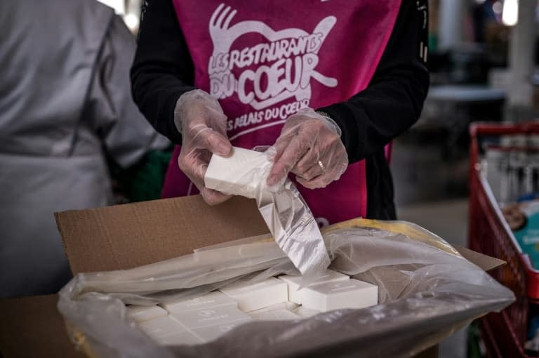 Des membres de l'association Les Restos du Cœur emballent des savons recyclés pour les bénéficiaires, le 24 mars 2021 à Givors - JEFF PACHOUD © 2019 AFP