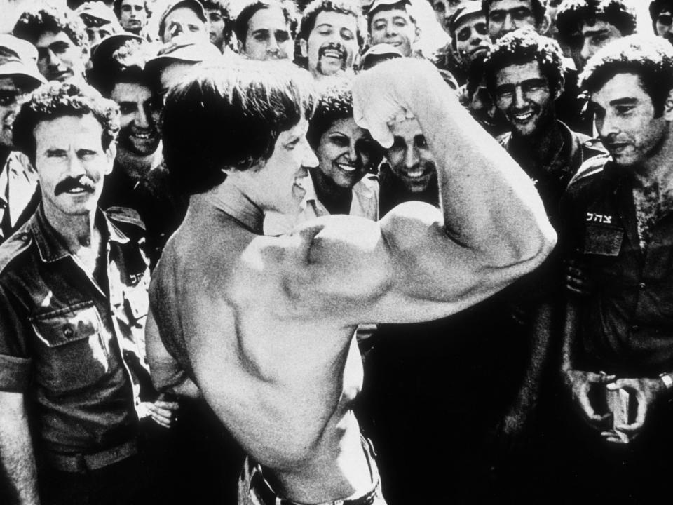 Arnold Schwarzenegger shows off his biceps to IDF soldiers in Israel.