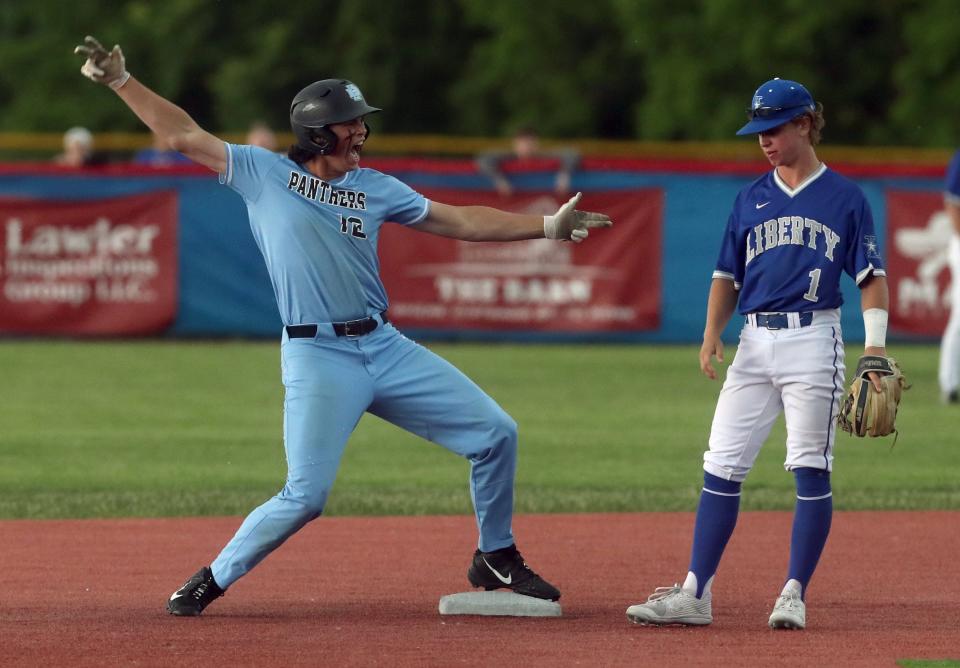 Hilliard Darby's Casey Maruniak celebrates a two-run double in front of Olentangy Liberty's Josh Stickel during a Division I district final May 26 at Grove City. The game was suspended because of rain with Darby leading  4-0 in the second inning.