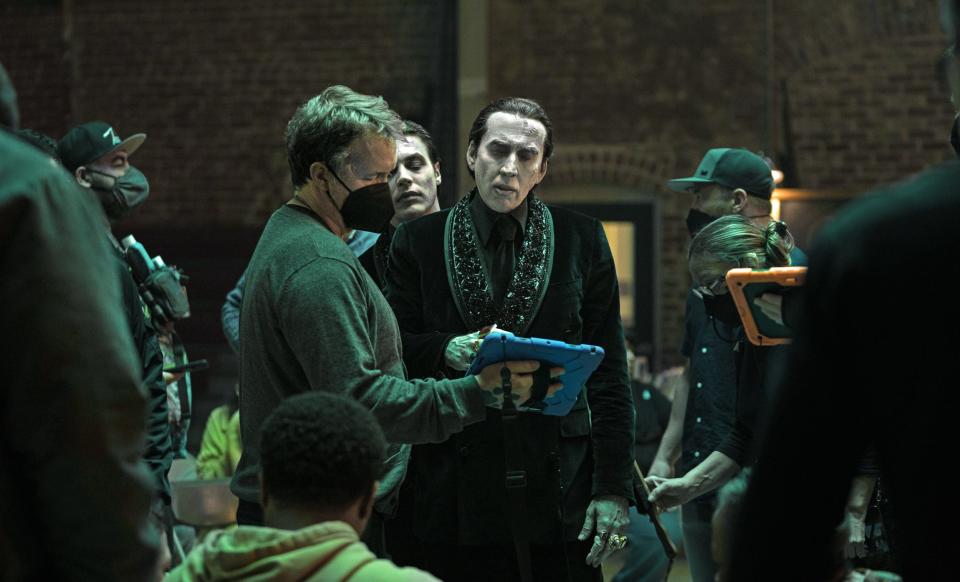 Chris McKay in a mask looping at an iPad with Nicolas Cage dressed as Dracula on the set of Renfield