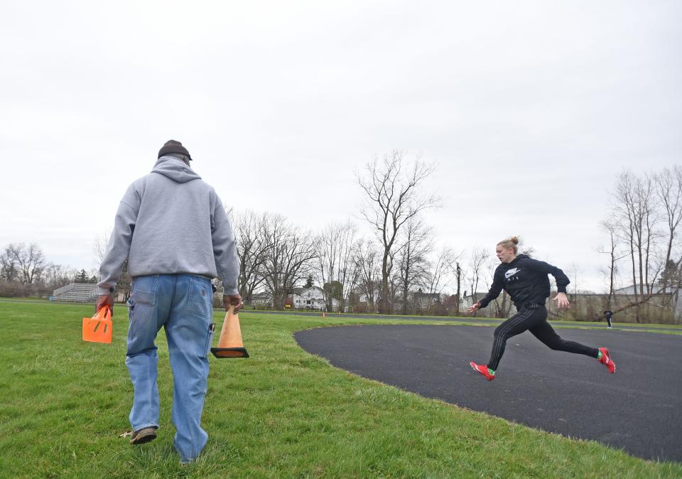 Tygers track coach Tyree Shine helps a high jumper with her stride and spacing Thursday afternoon during practice.