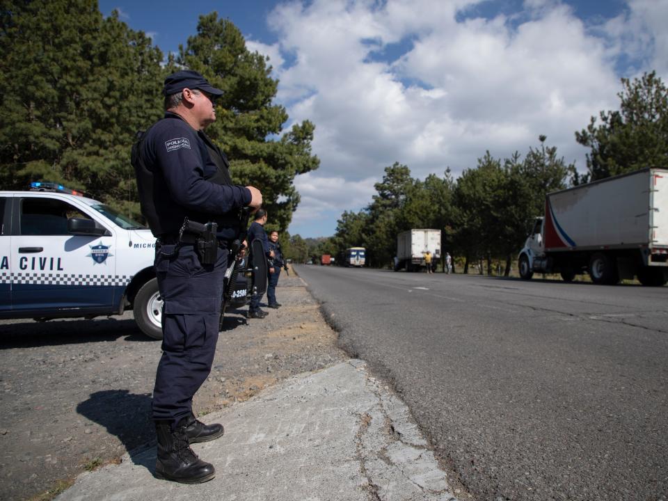 Police guard trucks loaded with avocados on their way to the city of Uruapan in Santa Ana Zirosto, Michoacan state, Mexico, Thursday, Jan. 26, 2023.