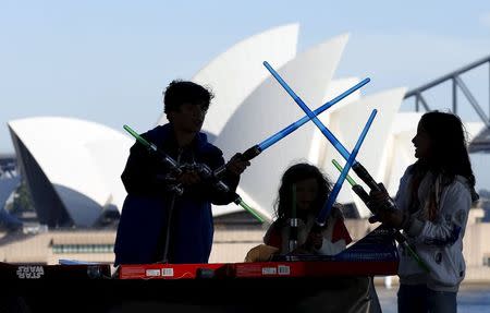 Caleb (L-R), Kayley and Annie Bratayley from the United States participate in a live internet unboxing event to reveal new light saber toys from the film "Star Wars - The Force Awakens" in Sydney, September 3, 2015. REUTERS/Jason Reed