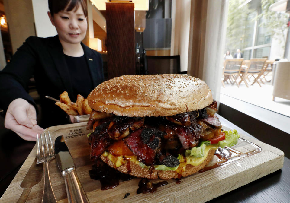 In this Thursday, March 28, 2019, photo, a "golden giant burger" is served at a restaurant of Hotel Grand Hyatt Tokyo in Tokyo. The $900 wagyu (Japanese-produced beef) burger was unveiled to commemorate the era change. What’s in a name? Quite a lot if you’re a Japanese citizen awaiting the official announcement Monday, April 1, 2019 of what the soon-to-be-installed new emperor’s next era will be called. It’s a proclamation that has happened only twice in nearly a century, and the new name will follow Emperor Naruhito, after his May 1 investiture, for the duration of his rule, attaching itself to much of what happens in Japan. (Kyodo News via AP)