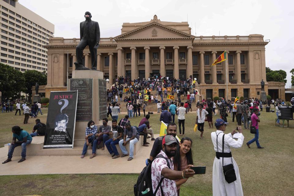 Protesters walk around and spend time at the ongoing protest site a day after storming into president's office in Colombo, Sri Lanka, Sunday, July 10, 2022. Sri Lanka’s opposition political parties will meet Sunday to agree on a new government a day after the country’s president and prime minister offered to resign in the country’s most chaotic day in months of political turmoil, with protesters storming both officials’ homes and setting fire to one of the buildings in a rage over the nation’s economic crisis. (AP Photo/Eranga Jayawardena)