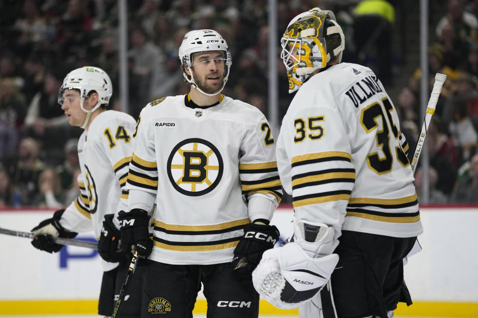 Boston Bruins defenseman Parker Wotherspoon, center, and goaltender Linus Ullmark (35) talk during the first period of an NHL hockey game against the Minnesota Wild, Saturday, Dec. 23, 2023, in St. Paul, Minn. (AP Photo/Abbie Parr)