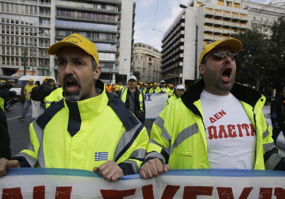 Protesters, the one on right wearing a T-shirt reading, 'Not for Sale'' shout slogans during a rally by hundreds of striking port workers outside the Greek Parliament in Athens, on Wednesday, Feb. 26, 2014. Greek dock workers across the country walked off the job Wednesday in a 24-hour strike to protest plans to sell a stake in the Piraeus Port Authority, the country's largest port. Privatizing state-held assets is a key part of Greece's international bailout agreement. (AP Photo/Thanassis Stavrakis)