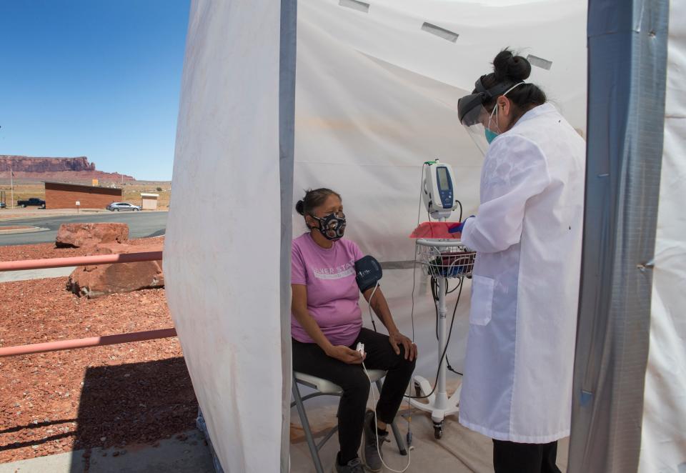 A nurse checks the vitals of a Navajo Indian woman at a COVID-19 testing center at the Navajo Nation town of Monument Valley in Arizona on May 21, 2020. Monument Valley would normally be teeming with tourists at this time of year -- instead it's become the latest COVID-19 hotspot inside the hard-hit Navajo Nation, America's biggest Native American territory. (Photo: MARK RALSTON via Getty Images)