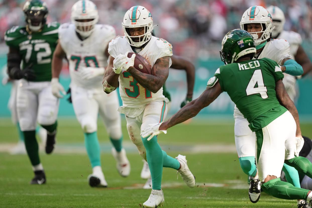 Miami Dolphins running back Raheem Mostert (31) breaks free for a big gain as New York Jets cornerback D.J. Reed (4) closes in during the second half of an NFL game at Hard Rock Stadium in Miami Gardens, Dec. 17, 2023.