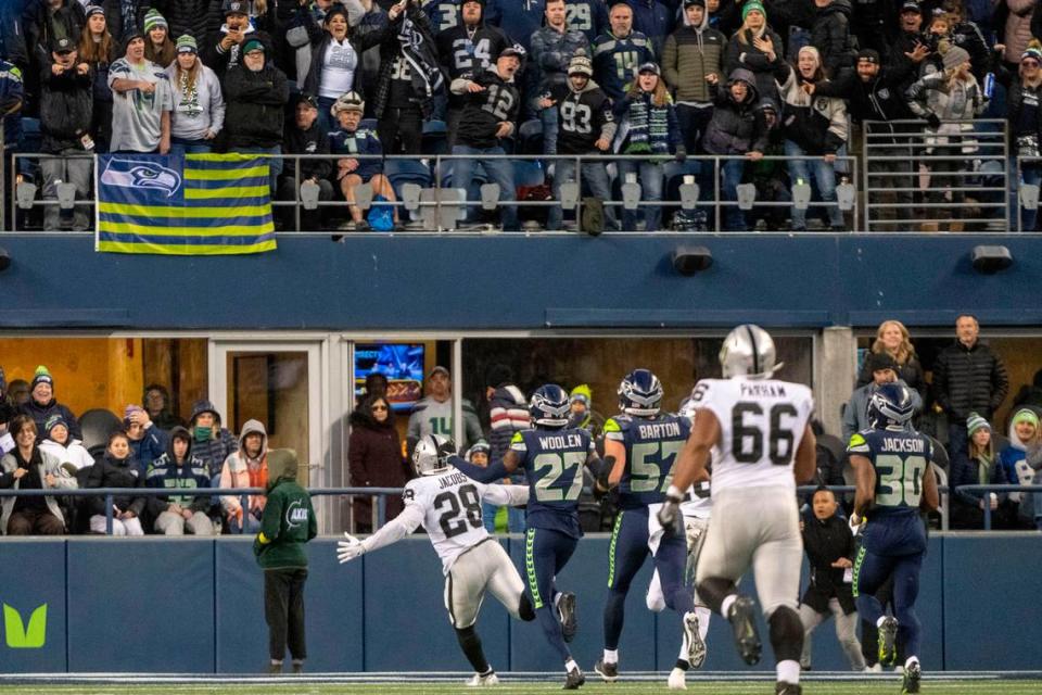 Fans react as Las Vegas Raiders running back Josh Jacobs (28) runs into the endzone for the game-winning touchdown in overtime of an NFL game on Sunday, Nov. 27, 2022, at Lumen Field in Seattle. Las Vegas beat Seattle, 40-34.