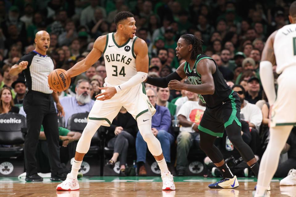 Bucks forward Giannis Antetokounmpo scans the court while being defended by Celtics guard Jrue Holiday during the first half Wednesday night at TD Garden.