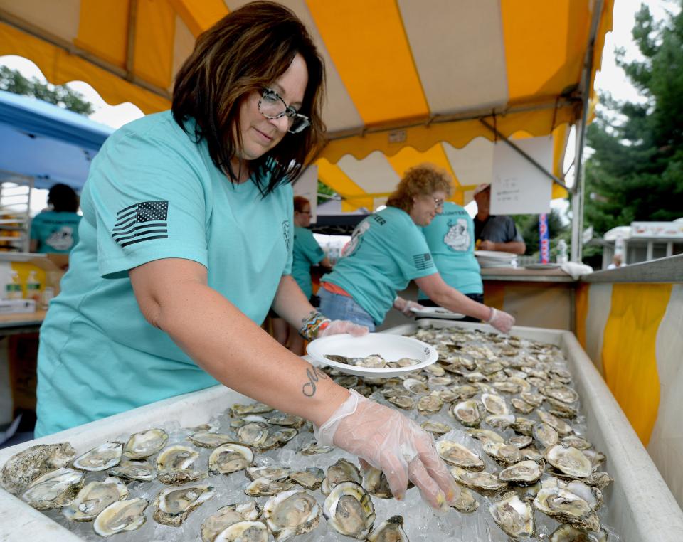 Volunteer Mary Galassi of Springfield gathers up raw oysters for customers at the Springfield Oyster and Beer Festival at Inn at 835 in Springfield Saturday Sept. 3, 2022.